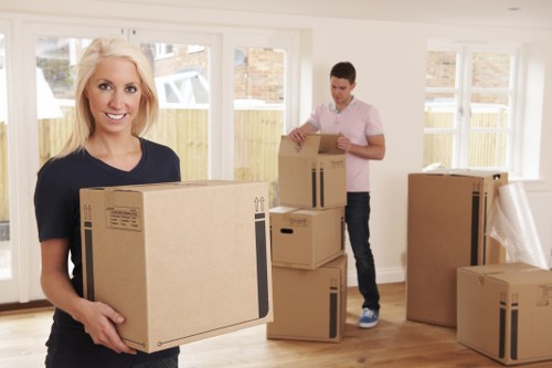 Moving team preparing boxes safely beside a van