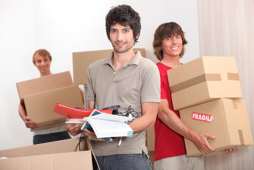 A Brockley flat move with movers carrying boxes down stairs