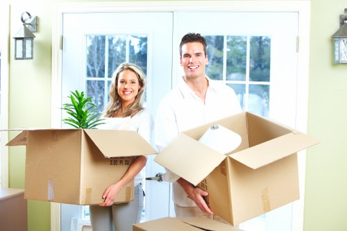 Professional movers carrying household items through a Brockley property